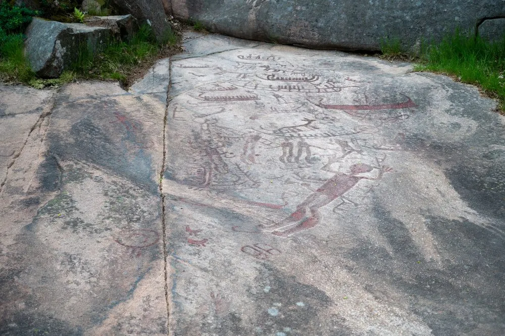 Rot nachgezogene Felsritzungen mit Schiffen und Figuren, die Backa Rock Carvings in Brastad