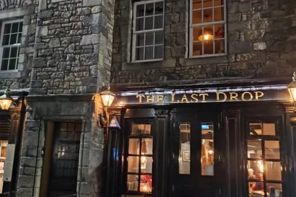 Der Pub The Last Drop in der Edinburgher Altstadt mit erleuchteten Fenstern in der Dämmerung