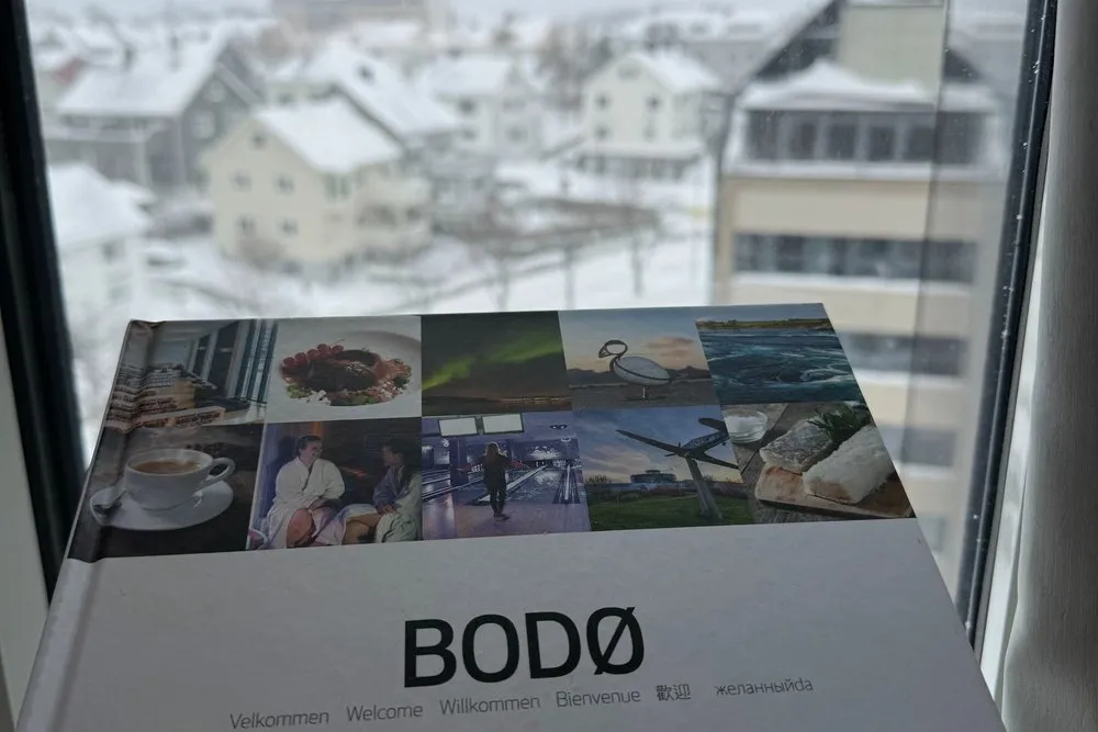 Ein Bodø-Prospekt auf der Fensterbank, draussen die verschneite Stadt