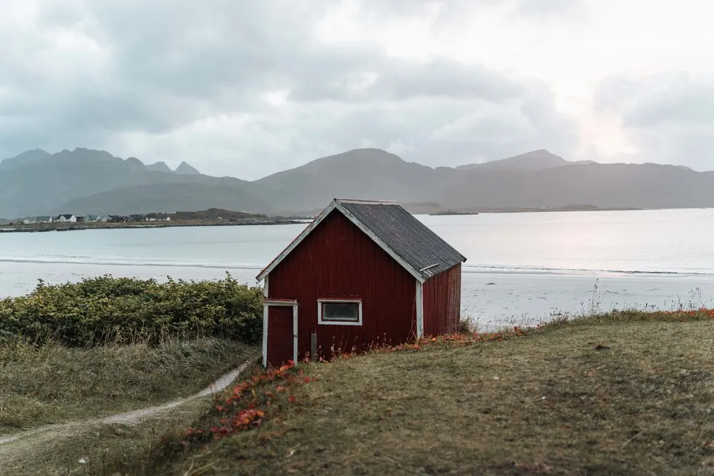 Das bekannte rote Häuschen über dem Rambergstranda, dahinter der helle Strand und die Berge