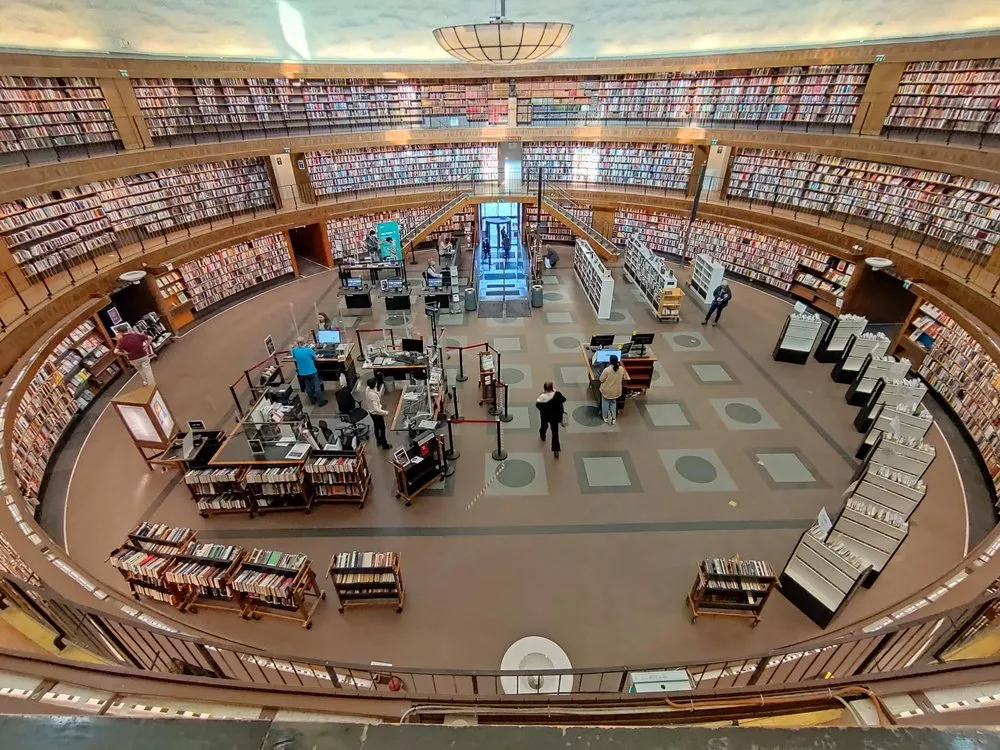 Blick von oben in die runde Halle der Stadtbibliothek, Bücherregale an den Wänden und Ausleihtheken in der Mitte