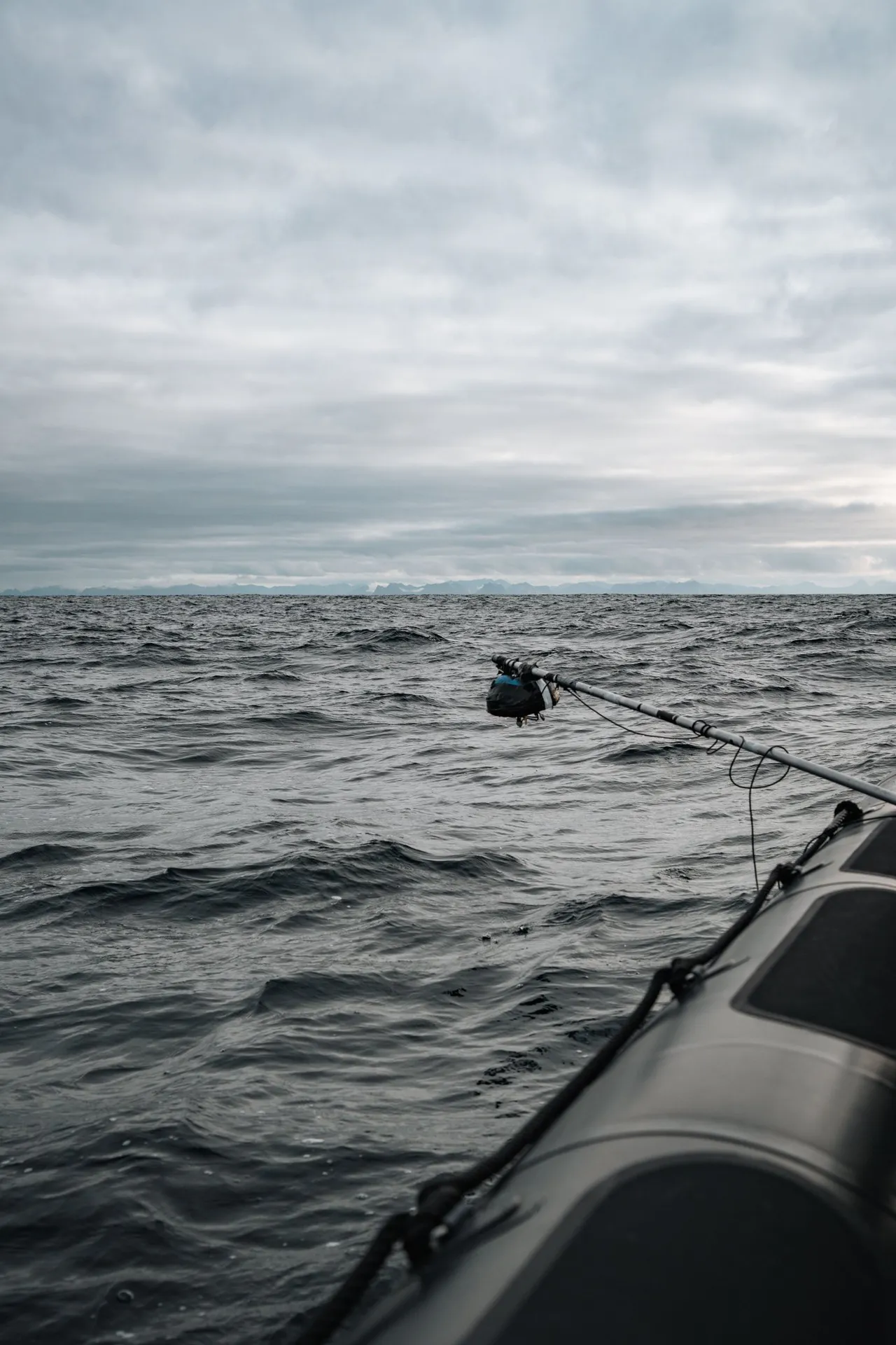 The hydrophone on a metal rod reaching out from the inflatable boat over the grey sea off Andenes